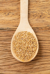 Closeup of golden linseed seeds on a wooden spoon