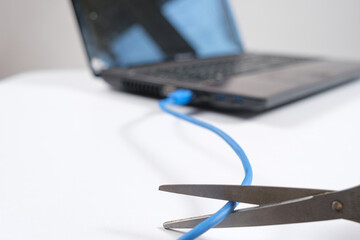 Scissors cut the Internet cable connected to the laptop. Turning off the internet, wi-fi