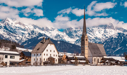 Winter landscape with a church and the famous Hochkoenig summit in the background at Maria Alm,...