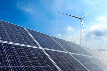 Solar panels and wind turbines landscape under blue sky. Green energy concept.