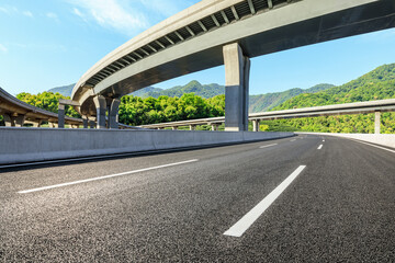 Empty asphalt road and bridge with mountains background