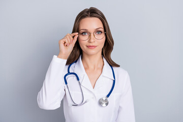 Portrait of calm confident person arm touch spectacles look camera isolated on grey color background