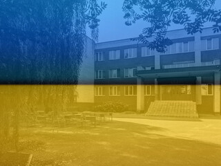 Ukraine flag. Empty school yard with desks for pupils. Studying outdoors. Coronavirus outbreak lifestyle: outdoor school activities with social distancing measures. Back to school during quarantine