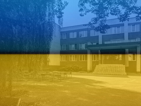 Ukraine flag. Empty school yard with desks for pupils. Studying outdoors. Coronavirus outbreak lifestyle: outdoor school activities with social distancing measures. Back to school during quarantine