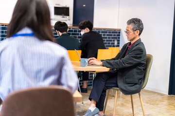 カフェで仕事をする中年男性