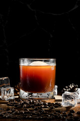 Iced black coffee in a mug placed on a wooden table with coffee beans