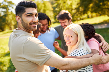 Young people embrace as a community in a circle