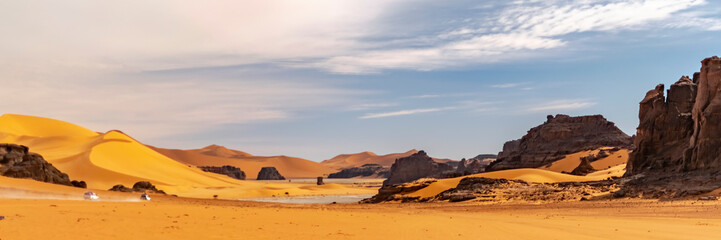 Panoramic view of Sahara Desert sand dune and rocky mountains in Tadrart Rouge, Djanet, Illizi. Far...