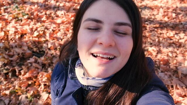 A woman whirls in the autumn forest, enjoys the sun's rays and good weather