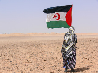 Woman holding Western Sahara flag in the desert