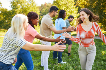 Group in the park while clapping for team building