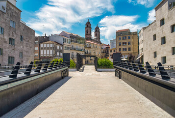 Calle peatonal en la ciudad de Vigo con los campanarios de la catedral al fondo, España