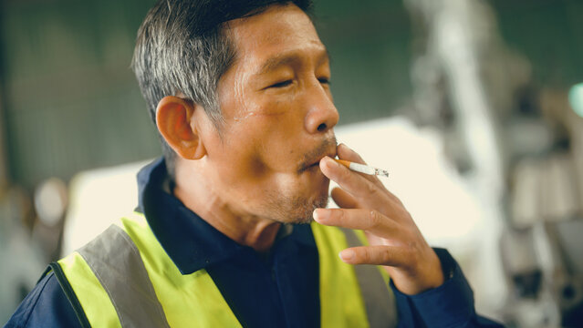 Factory Worker Smoking During Lunch Break