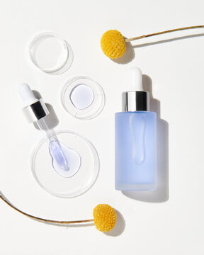 Bottle of hyaluronic acid near flowers