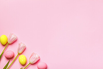 Easter composition. Eggs and spring flowers tulips on a pink background.