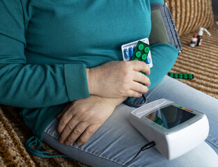 Senior woman measure blood pressure. Device for self-diagnosis and control of the heart. High or low pressure. Hypertension or hypotension. The concept of cardiovascular disease