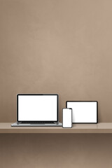 Laptop, mobile phone and digital tablet pc on brown wall shelf. Vertical background