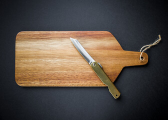 Traditional japanese pocket knife on a wooden cutting board