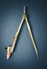 Old vintage pair of compasses on dark background