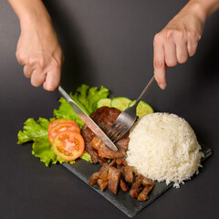 grilled beef with rice on plate over black background studio