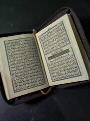 Obraz premium Probolinggo East Java Indonesia, 21 March 2022 - Pocket Quran Islam holy book of Muslims isolated on black background