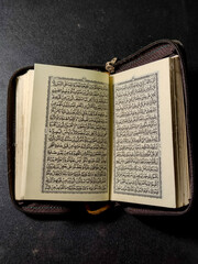 Obraz premium Probolinggo East Java Indonesia, 21 March 2022 - Pocket Quran Islam holy book of Muslims isolated on black background