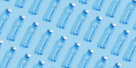 Pattern with blue plastic bottles on blue paper background, top view empty plastic bottle for water...