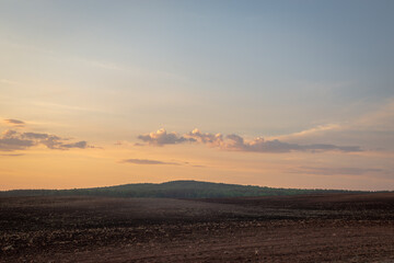 Hills, field and sky at sunset.