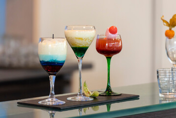 3 cocktails servis au bar d'un restaurant. Couleurs gourmandes et formes variées.