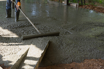 pouring concrete with worker mix cement at construction site.
