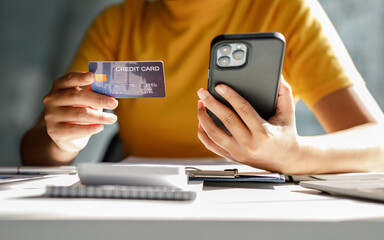 Close up hand of business woman using a credit card and mobile smartphone for payments and online shopping, Online shopping, digital banking, E-commerce concept.