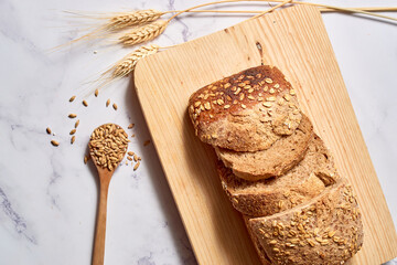 A loaf of sourdough rye bread on a rustic wooden board.