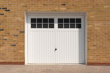 Classic look, white side hinged garage doors, on a new build home.  UK - obrazy, fototapety, plakaty