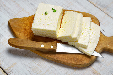 tasty lunch in rural style, healthy food - sliced feta cheese and green leek on a white wooden boards