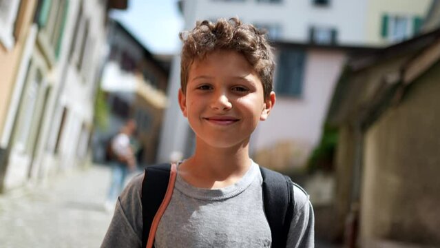 One happy handsome young boy walking in street smiling