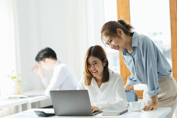 2 businesswomen working on line watching webs in a laptop in a bar with a window and and outdoors in the background