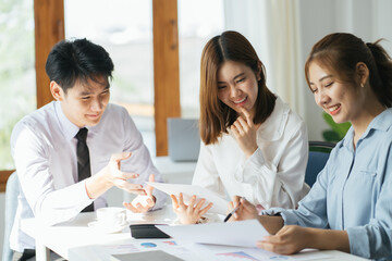 Serious concentrated multiethnic diverse young creative team students group talking brainstorming discussing online business project working at desk using laptop computer in office classroom.