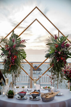 Close-up photo of beautiful Wedding decoration with flowers outdoor Wedding metal arch decoration indoor form of a rhombus, decorated with flowers