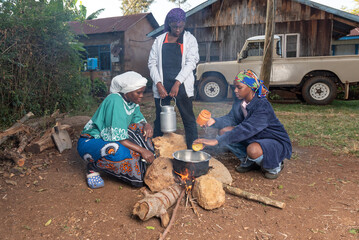 African Teenage girl stirring tea leaves into pot 