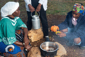 African Teenage girl stirring tea leaves into pot 