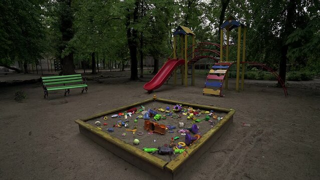 toys on the playground abandoned by children who fled the war. homeless children hopelessness, ruins from bombs. frightened poor victims of terrorism. broken family crisis