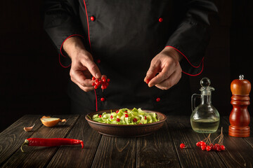 Preparation of salad from viburnum and cabbage. The chef prepares a salad for breakfast or lunch in the kitchen. European cuisine
