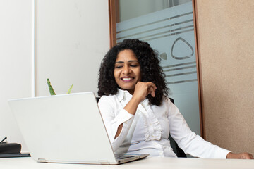 smiling woman using laptop in office