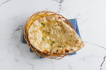 Crispy garlic naan in a basket isolated on napkin side view on grey background famous indian and...