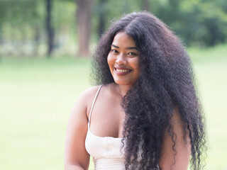 Portrait of beautiful dark skinned Asian woman with long curly hair.