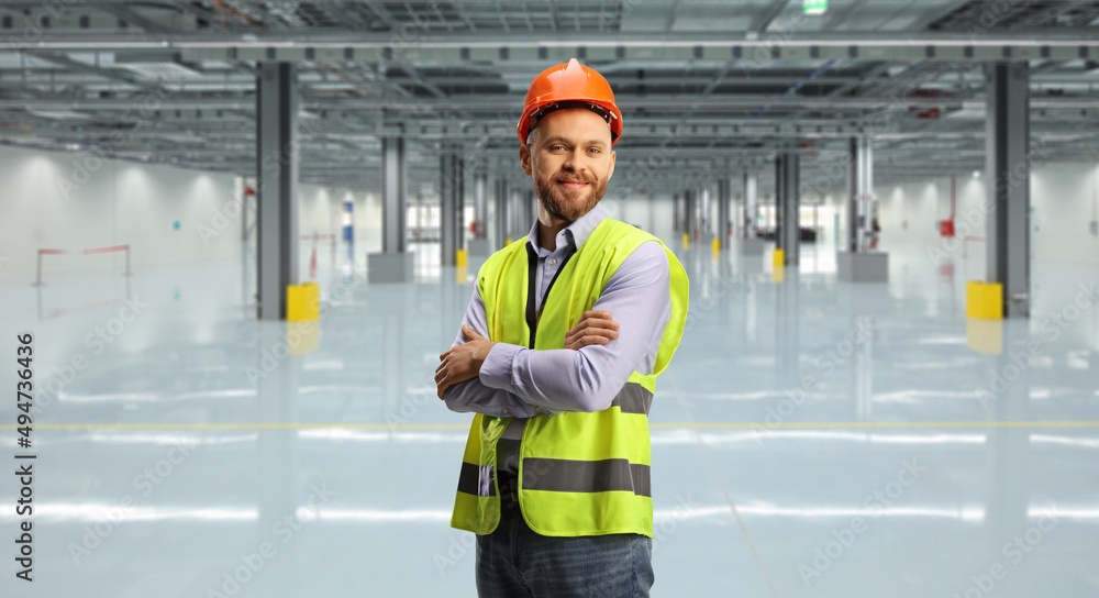 Wall mural engineer wearing a reflective vest and helmet in a hall