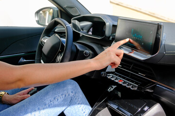 Naklejka premium Woman's hands managing the consumption of the electric car