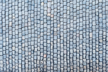 Cobblestone pavement texture background. Top view of stone road. Detail of granite sidewalk taken from above. Old street cobblestones for backdrop. Abstract vintage pavement with rough blocks.