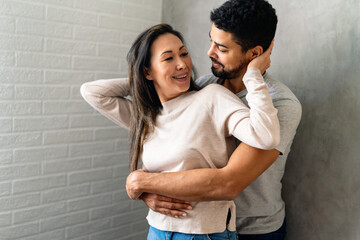 The lovely multiethnic couple spends time together, hugging and smiling