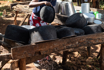 Young Teenage African Girl washing dishes at and outdoor area